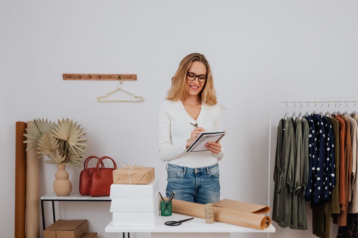 Dueña de una tienda de ropa revisando su inventario y paquetes listos